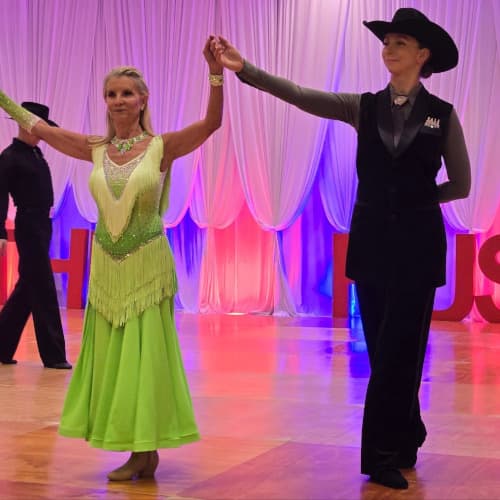 Stacey dancing as a Pro lead presenting her student to the audience